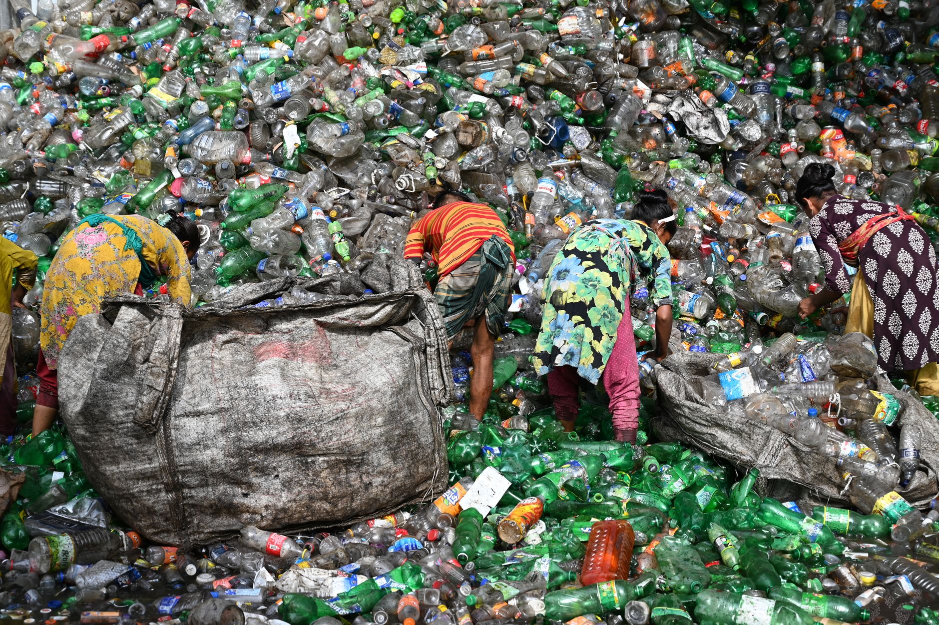 Workers sorting plastic waste at a landfill in Chattogram, Bangladesh. Environmental and recycling theme. — PET Recycling Off
